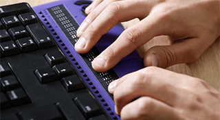 Computernutzer mit Braille Computereingabe